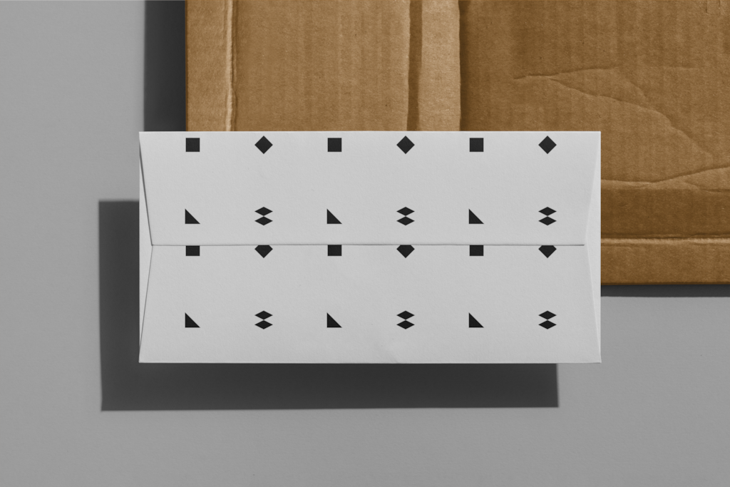 Envelope 05 — On cardboard mockup surface