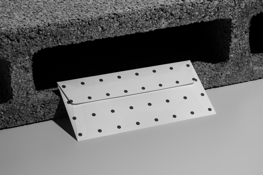 Envelope 02 — On concrete mockup surface