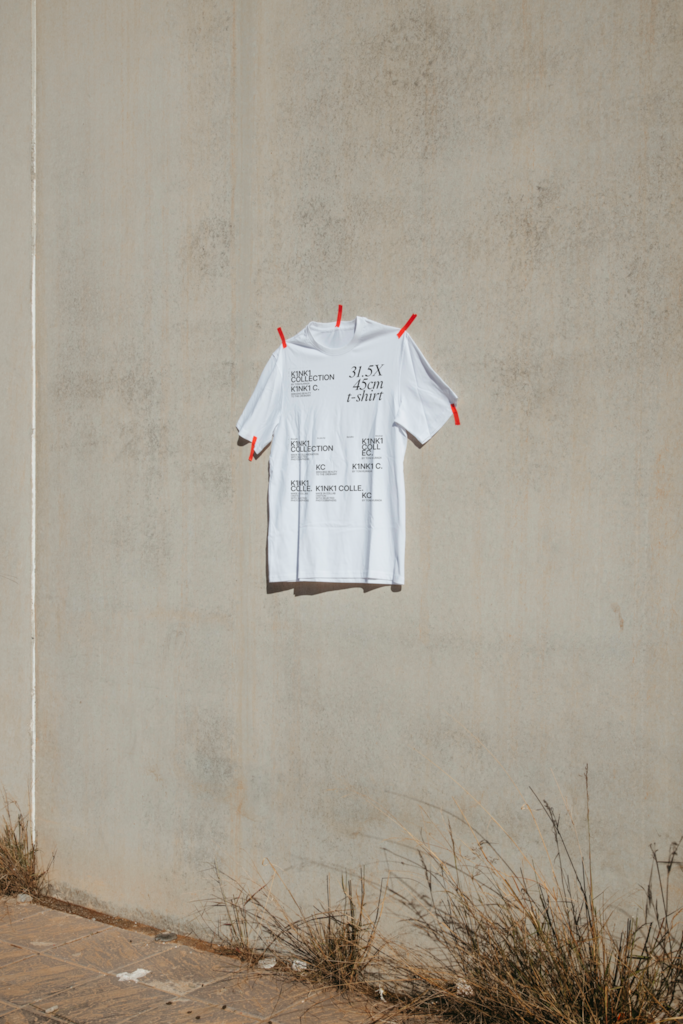 K T-Shirt 02 — Front, on wall mockup surface